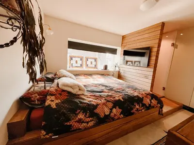 a bedroom with a bed with a blanket on it at de Bunker Katwijk in Katwijk