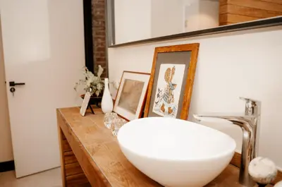 a bathroom with a white bowl on a wooden counter at de Bunker Katwijk in Katwijk