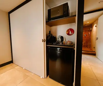 a kitchen with a black refrigerator and a microwave at de Bunker Katwijk in Katwijk