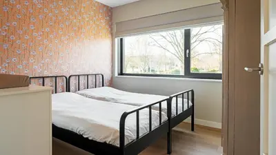 a small bedroom with a bed and a window at Villa Endless Summer in Bergen