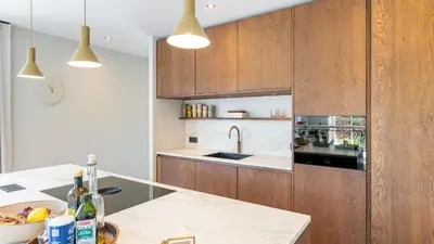 a kitchen with wooden cabinets and a counter top at Villa Endless Summer in Bergen