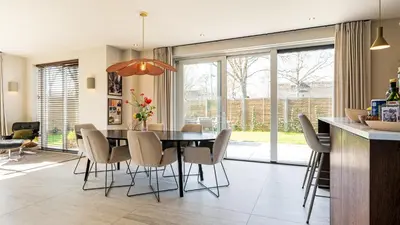 a kitchen and dining room with a table and chairs at Villa Endless Summer in Bergen