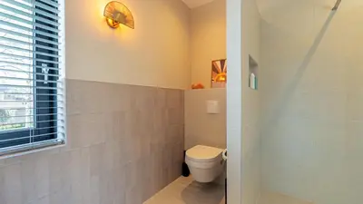 a bathroom with a toilet and a window at Villa Endless Summer in Bergen
