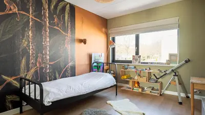 a bedroom with a tree mural on the wall at Villa Endless Summer in Bergen