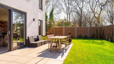 a patio with a table and chairs in a yard at Villa Endless Summer in Bergen