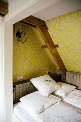 a bed in a room with a yellow wall at Louisehoeve Holiday Home in Linschoten
