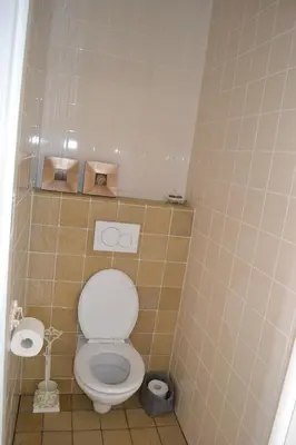 a bathroom with a toilet in a tiled room at Louisehoeve Holiday Home in Linschoten
