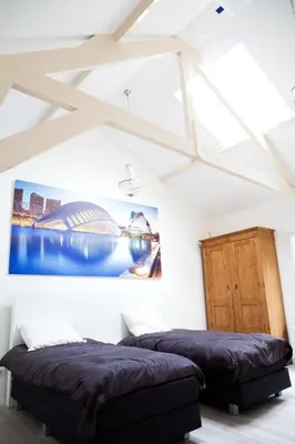 two beds in a room with white walls and ceilings at La Casita bed and breakfast in Voorschoten