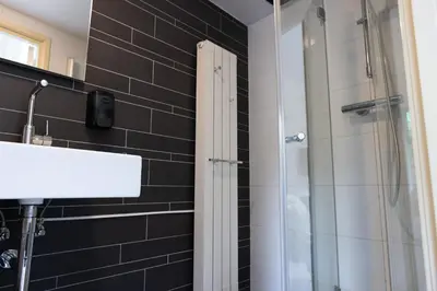 a bathroom with a shower with a glass door at La Casita bed and breakfast in Voorschoten