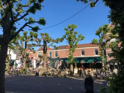 a street with tables and chairs and a building at La Casita bed and breakfast in Voorschoten