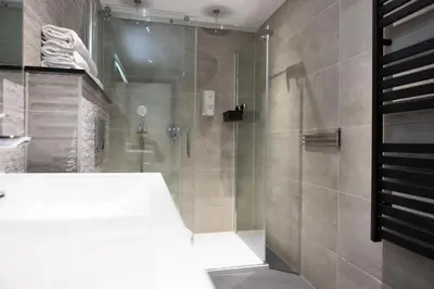 a bathroom with a shower with a glass door at La Casita bed and breakfast in Voorschoten