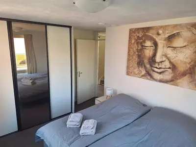 a bedroom with a bed and a large mirror at Have a nice stay! - Juul's Rooftop, free parking in Noordwijk