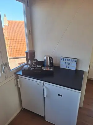 a kitchen with a black counter top and a window at Have a nice stay! - Juul's Rooftop, free parking in Noordwijk
