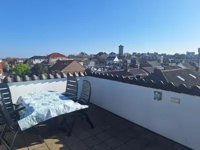 a table and chairs on a balcony with a view at Have a nice stay! - Juul's Rooftop, free parking in Noordwijk
