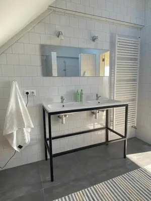 a bathroom with a sink and a mirror at Amsterdam Garden Studio in Uitdam