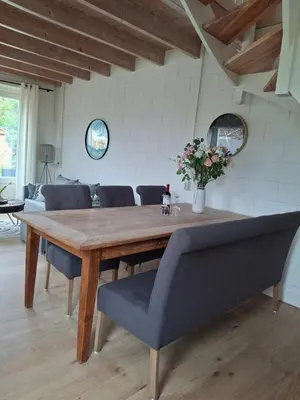 a dining room table with chairs and flowers on it at Huisje Suus, inclusief jacuzzi, kano en kajak in Zuid-Scharwoude