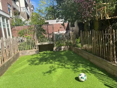 a soccer ball sitting on the grass in a yard at 185m2 groot appartement met tuin in City Centre in Amsterdam