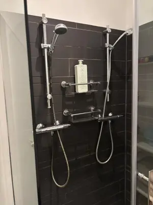 a bathroom with a shower with a hair dryer on the wall at 185m2 groot appartement met tuin in City Centre in Amsterdam
