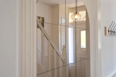 a hallway with a glass staircase and a mirror at Le Paysan in Wijk aan Zee