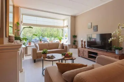 a living room with couches and a flat screen tv at Le Paysan in Wijk aan Zee