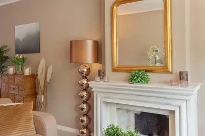 a living room with a fireplace and a mirror at Le Paysan in Wijk aan Zee