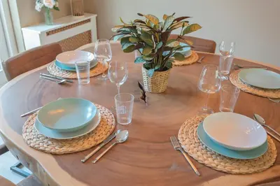 a wooden table with plates and silverware on it at Le Paysan in Wijk aan Zee
