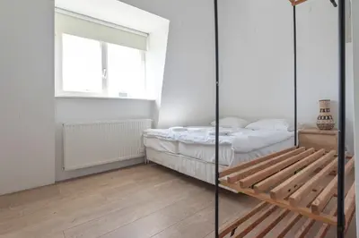 a small bedroom with a bed and a window at De Sonnehoeck Zandvoort in Zandvoort