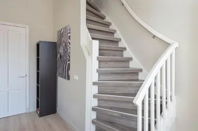 a staircase in a home with white walls and wooden floors at De Sonnehoeck Zandvoort in Zandvoort