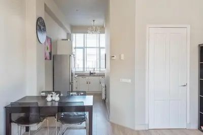 a kitchen with a table and chairs and a refrigerator at De Sonnehoeck Zandvoort in Zandvoort