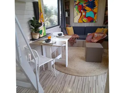 a living room with a table and a couch at Tiny House Egmond in Egmond aan den Hoef