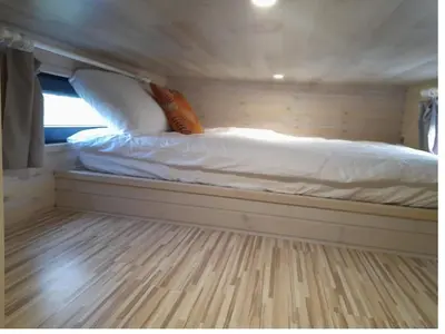 a bed sitting inside of a tiny house at Tiny House Egmond in Egmond aan den Hoef