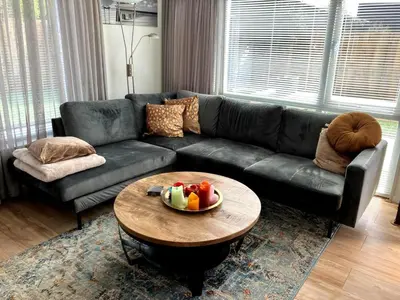 a living room with a couch and a table with a bowl of fruit at Casa Freddy in Noordwijkerhout