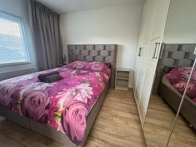 a bedroom with a bed with a purple blanket at Casa Freddy in Noordwijkerhout