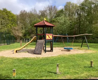 a playground with a slide and a swing at Casa Freddy in Noordwijkerhout