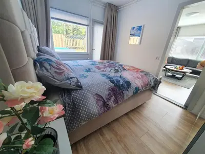 a bedroom with a bed with a floral comforter and a window at Casa Freddy in Noordwijkerhout