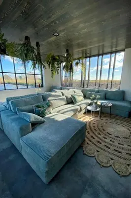 a living room with a blue couch and a table at Hidden Gem in Oost-Knollendam