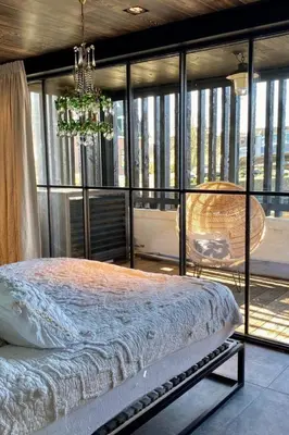 a bedroom with a bed and a large window at Hidden Gem in Oost-Knollendam
