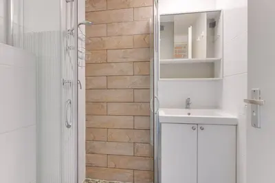 a white bathroom with a sink and a shower at Vakantiehuis met strand Noord-holland op 5 min & ruime tuin VP078 in Warmenhuizen