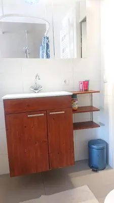 a kitchen with a sink and a blue trash can at House nearby Amsterdam in Almere