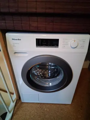 a washing machine is sitting on top of a washer at House nearby Amsterdam in Almere