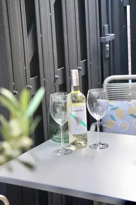a bottle of wine and two wine glasses on a table at Bed & Beach 114 in Noordwijk aan Zee