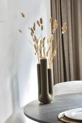 a table with two vases with flowers on it at Bed & Beach 114 in Noordwijk aan Zee