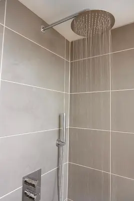 a shower with a shower head in a bathroom at Bed & Beach 114 in Noordwijk aan Zee