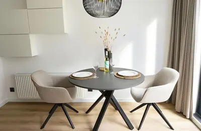 a dining room table with two chairs and a bottle of wine at Bed & Beach 114 in Noordwijk aan Zee