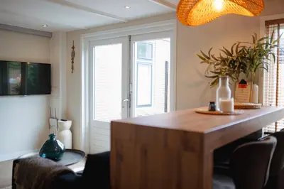 a kitchen with a wooden island in a room at Duijnparadijs in Schoorl