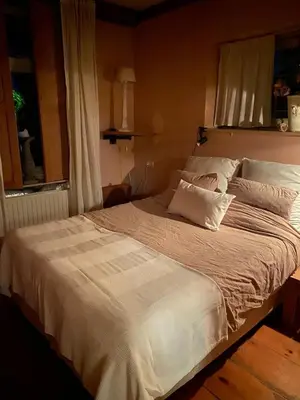 a large white bed in a bedroom with a window at The Beach House in Schellinkhout