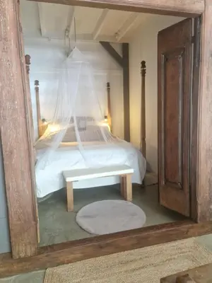 a bedroom with a bed with a table in a mirror at The Beach House in Schellinkhout