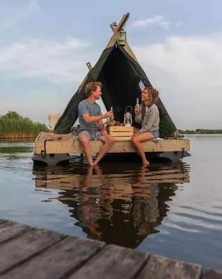 three men sitting on a raft in the water at Campingraft Katwoude in Katwoude