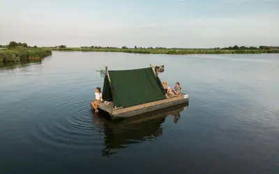 a group of people sitting on a boat in the water at Campingraft Katwoude in Katwoude
