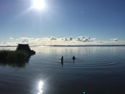 two people are swimming in a large body of water at Campingraft Katwoude in Katwoude